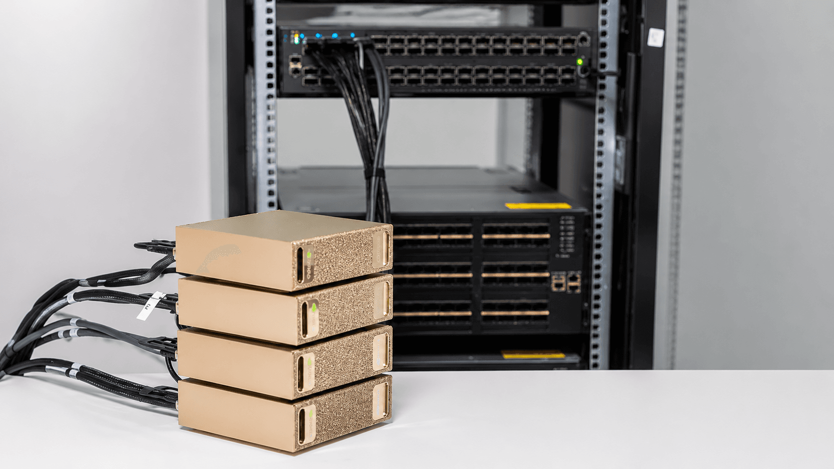 A stack of four NVIDIA DGX Spark units wired to a MikroTik switch on a desk.